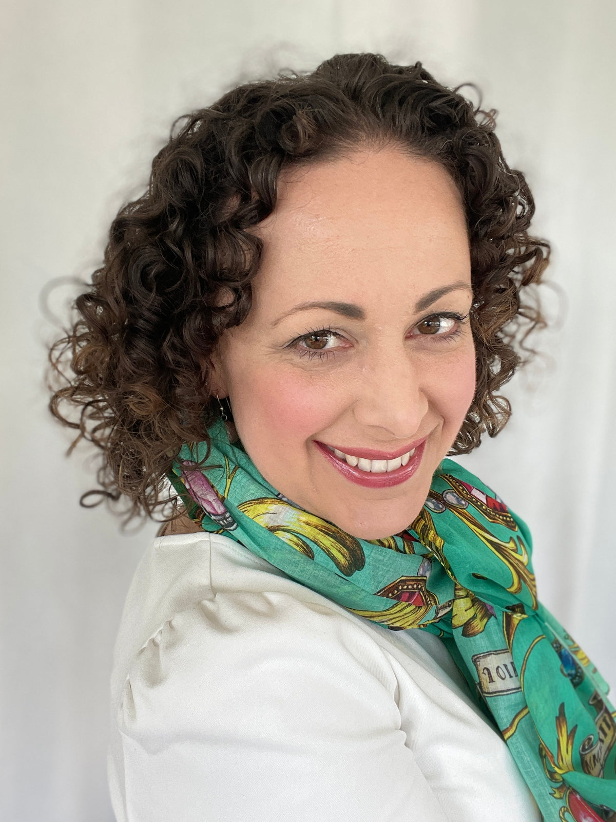 Portrait of artist Frida wearing a colorful turquoise scarf featuring her botanical artwork