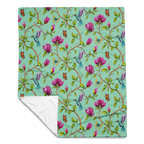 Magnolia Dreams throw blanket in Vista Blue, featuring pink magnolia blossoms, colorful hummingbirds, butterflies and green leaves