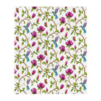 Magnolia Dreams throw blanket featuring pink magnolia blossoms, colorful hummingbirds, butterflies and green leaves on a white background