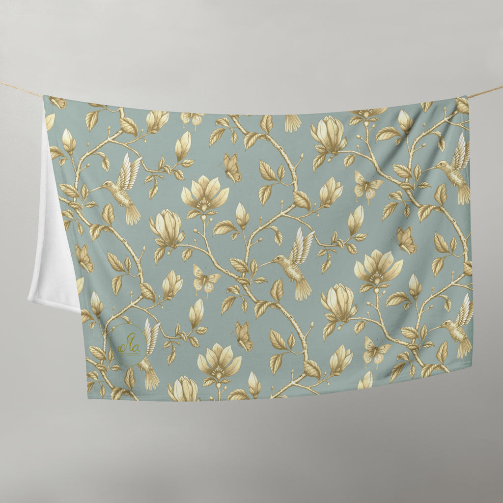 Magnolia Dreams Gilded Garden throw blanket in Turquoise & Gold, featuring golden magnolia blossoms, hummingbirds, butterflies and leafy branches