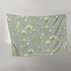 Magnolia Dreams Gilded Garden throw blanket in Turquoise & Gold, featuring golden magnolia blossoms, hummingbirds, butterflies and leafy branches
