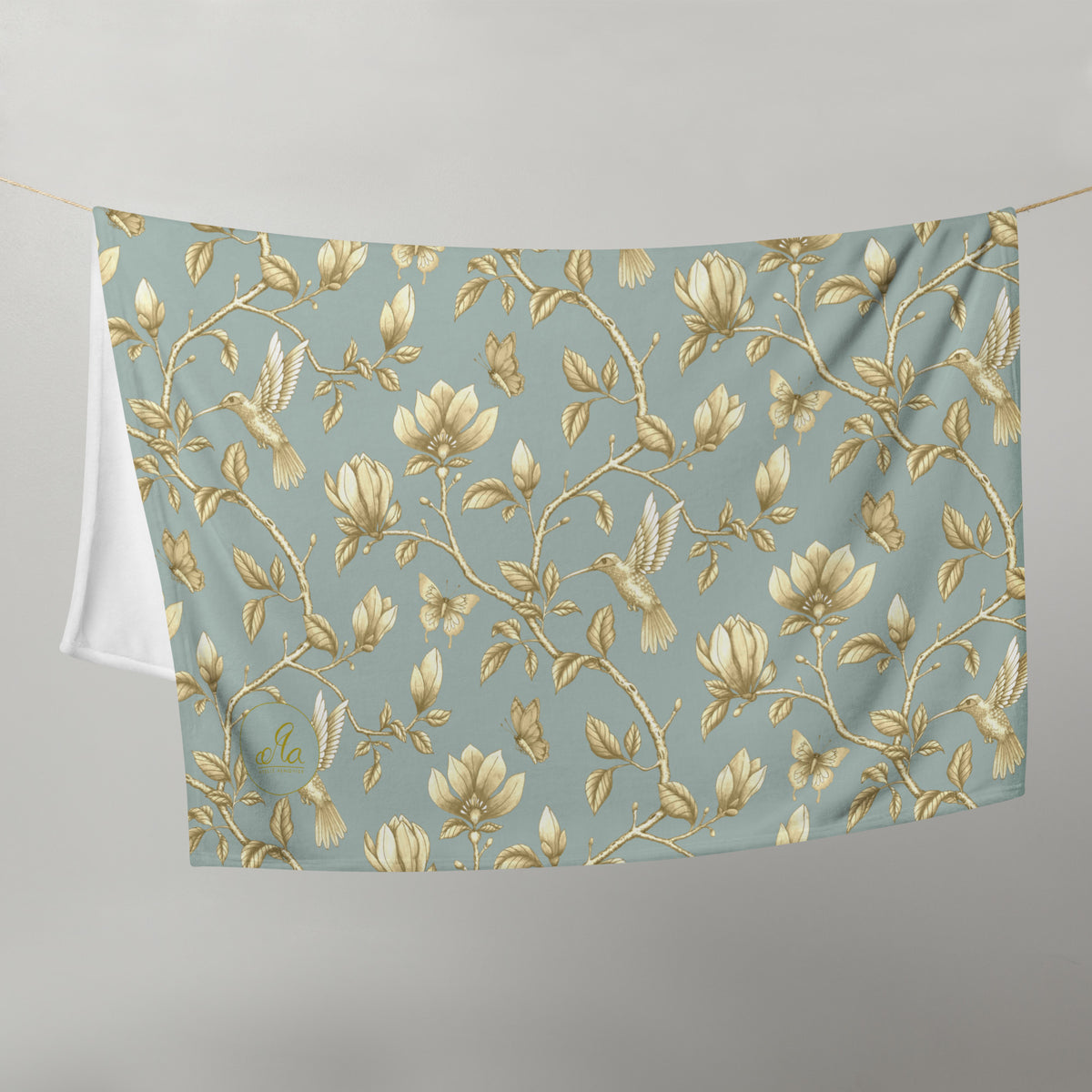 Magnolia Dreams Gilded Garden throw blanket in Turquoise & Gold, featuring golden magnolia blossoms, hummingbirds, butterflies and leafy branches