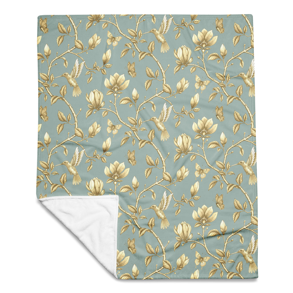 Magnolia Dreams Gilded Garden throw blanket in Turquoise & Gold, showcasing delicate magnolia blossoms, leaves and butterflies