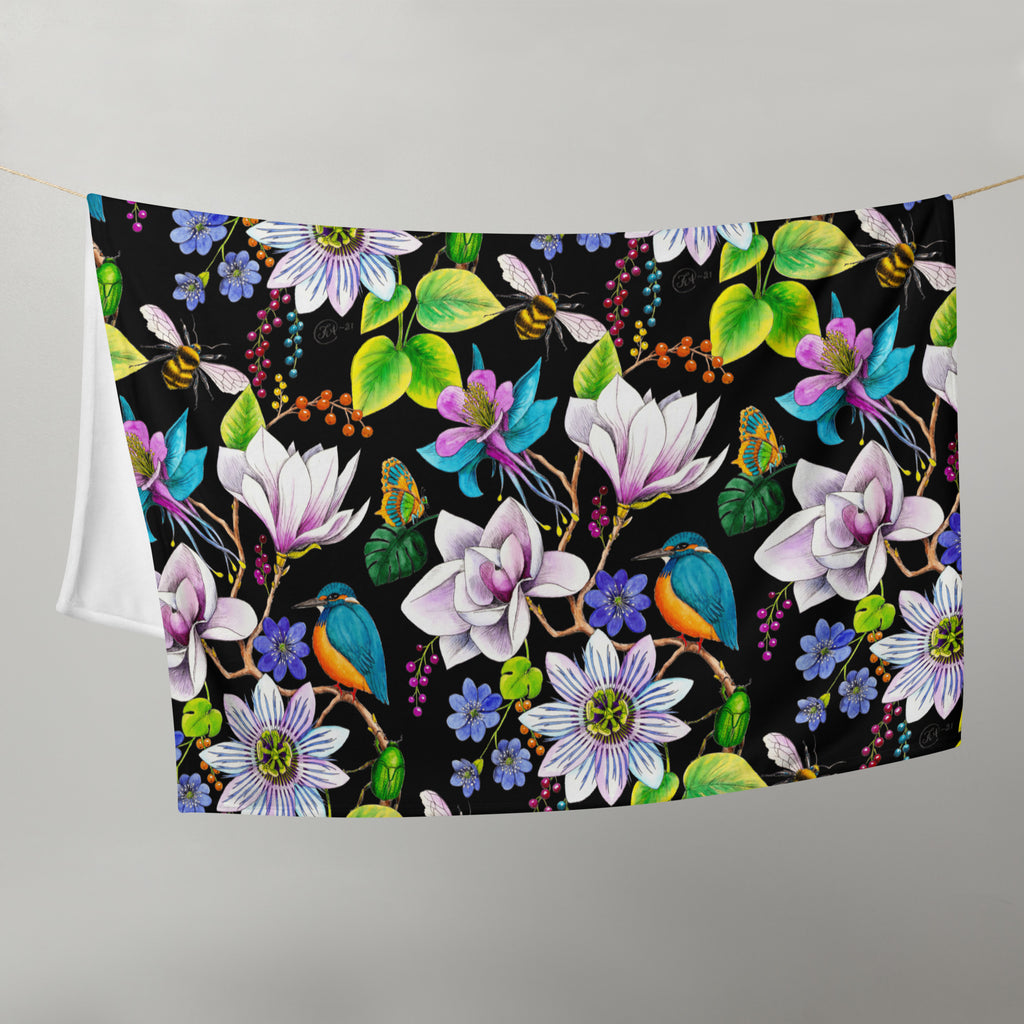 Garden of Eden throw blanket hanging on a line, featuring colorful exotic flowers, kingfishers, bumblebees, butterflies and green leaves on a black background