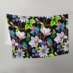 Garden of Eden throw blanket hanging on a line, featuring colorful exotic flowers, kingfishers, bumblebees, butterflies and green leaves on a black background