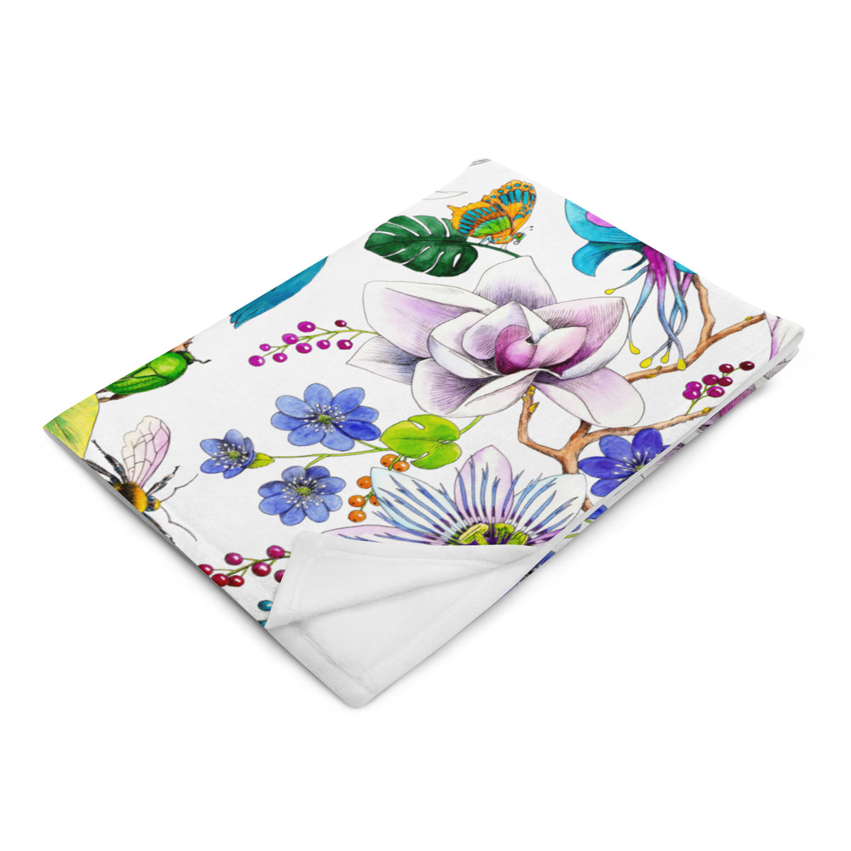 Garden of Eden throw blanket folded to show its colorful floral pattern with an exotic kingfisher, magnolia flowers and berries