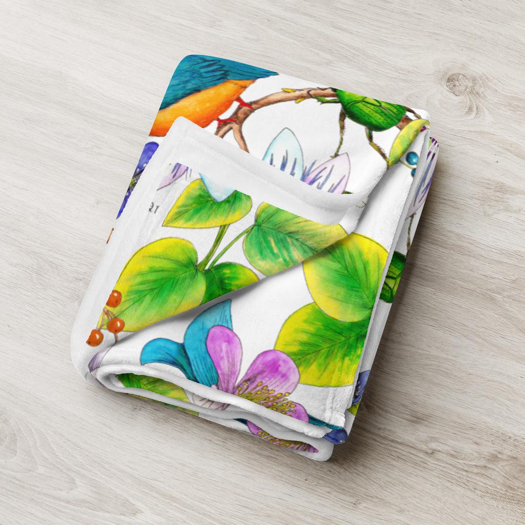 Folded throw blanket featuring the Garden of Eden floral pattern, with colorful exotic flowers, green leaves and a kingfisher