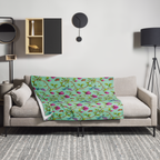 Magnolia Dreams throw blanket in Vista Blue, featuring pink magnolia blossoms, colorful hummingbirds and butterflies