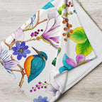 Close-up of a Garden of Eden throw blanket featuring an exotic kingfisher surrounded by colorful flowers and leaves
