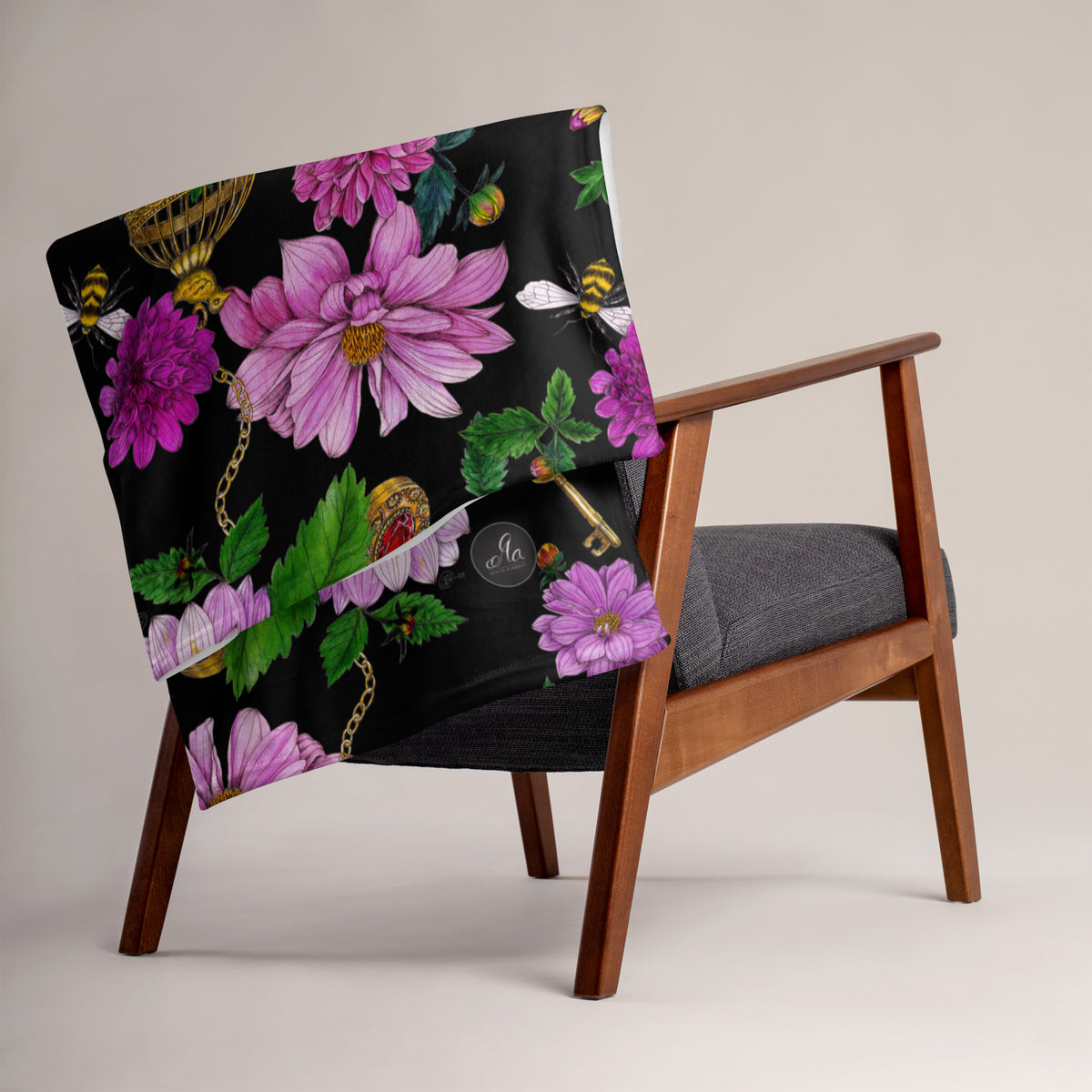 Dahlia Garden throw blanket draped over a chair, showing its colorful floral pattern with pink flowers, leaves and decorative birdcages